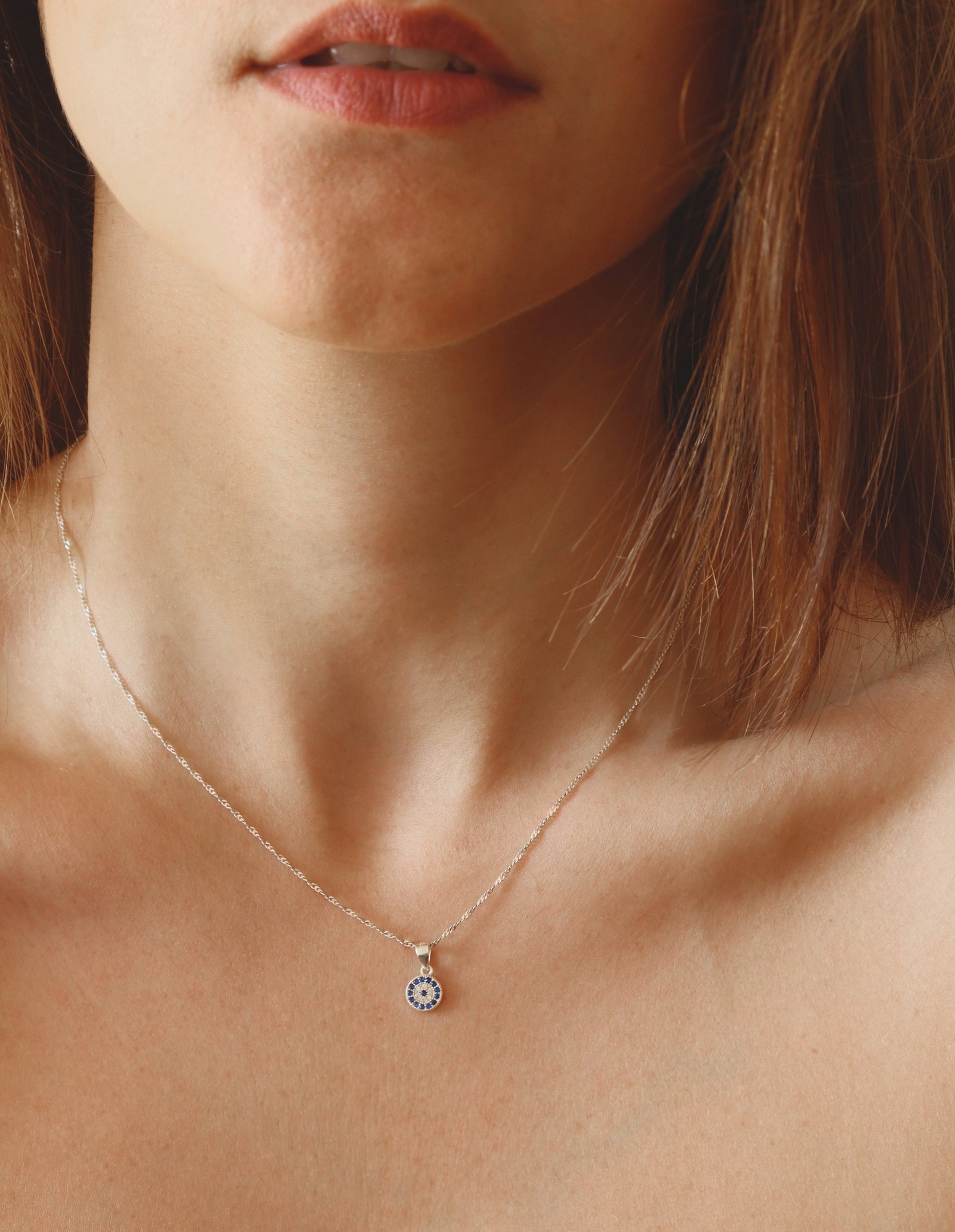 Dainty silver pendant necklace worn on the collarbone